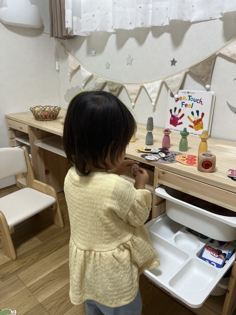 トロファスト上の天板にマグネットを広げて遊ぶ1歳8か月の子ども