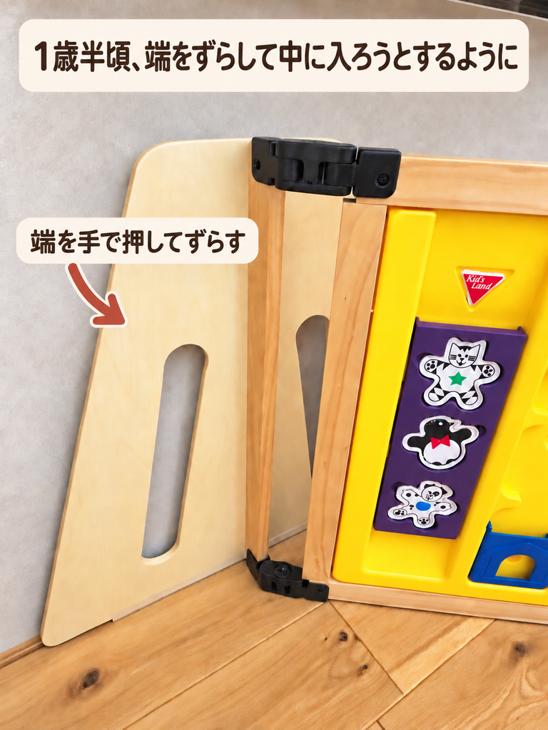 木製パーテーションの左端を写した写真。おもちゃパネルにつながる端の板を矢印で示し、「端を手で押してずらす」と記している。